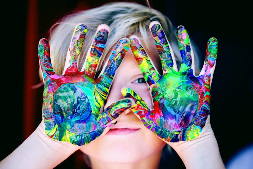 l’immagine rappresenta una bimba che sta giocando con i colori a tempera
