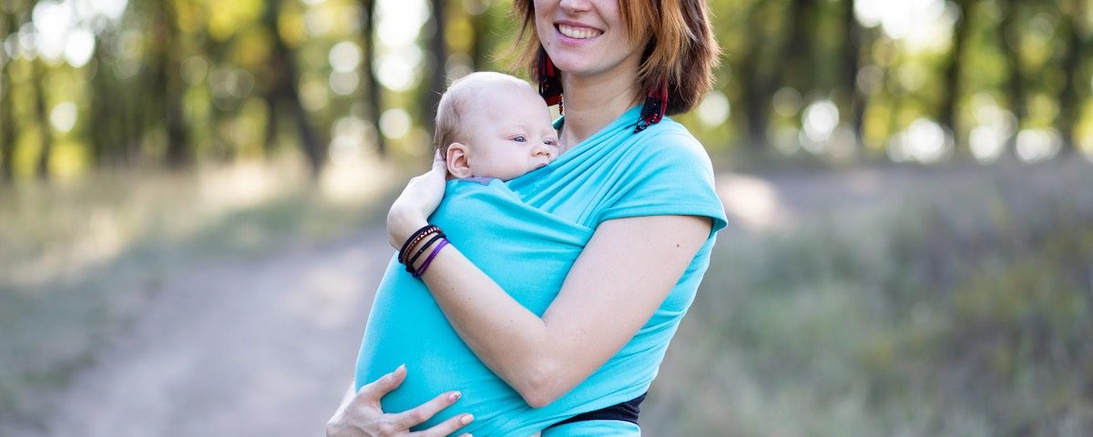 marsupio neonato, genitore che porta il neonato fronte mamma in modo sicuro