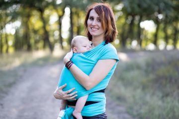 marsupio neonato, genitore che porta il neonato fronte mamma in modo sicuro