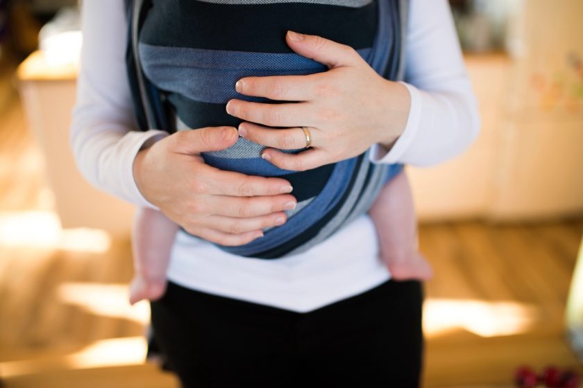 marsupio neonato, mani della mamma che regolano lo sling per una posizione sicura