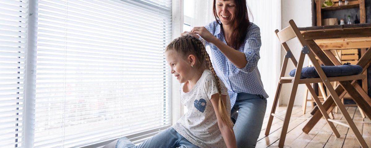 Madre controlla i capelli del bambino con pettine per individuare pidocchi e lendini