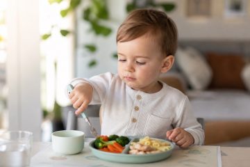 Bambino di 2 anni seduto a tavola con piatti sani e bilanciati