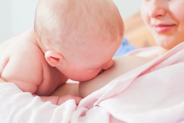 Neonato rigurgita latte sulla spalla della madre dopo la poppata