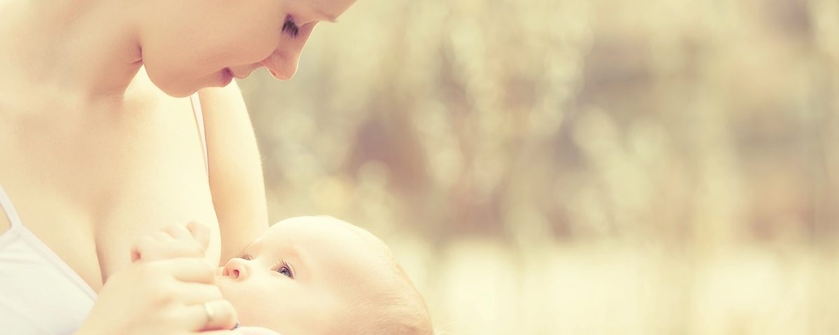 Mamma allatta il neonato in casa, immagine a tema capezzolo gonfio e cura del seno in allattamento.