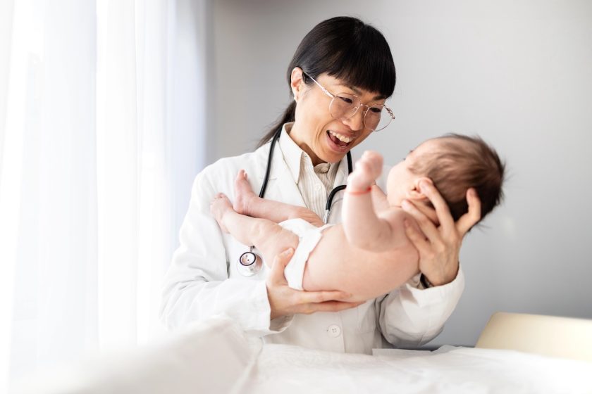 Pediatra visita un neonato durante un controllo, immagine a tema fontanella e crescita nei primi mesi.