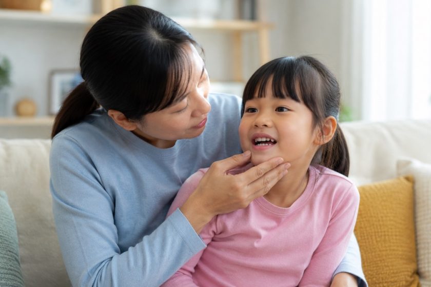 Genitore controlla la bocca di un bambino con possibile ematoma gengivale