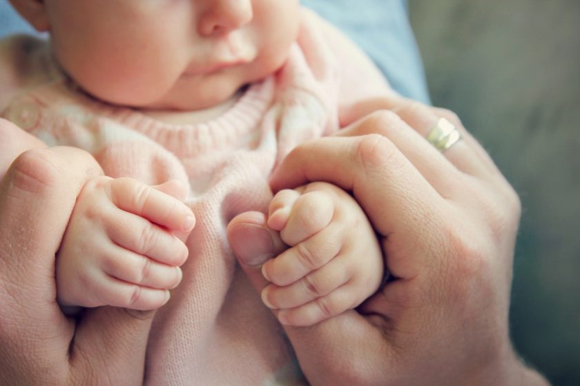 Neonato di 3 mesi che porta le mani alla bocca