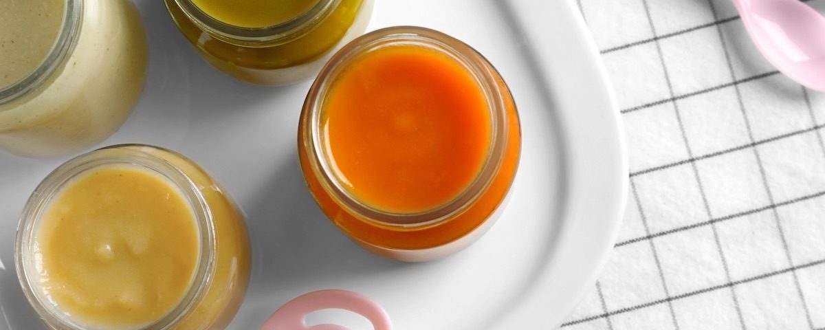 Vasetto di omogeneizzato cremoso accanto a una confezione di liofilizzato in polvere