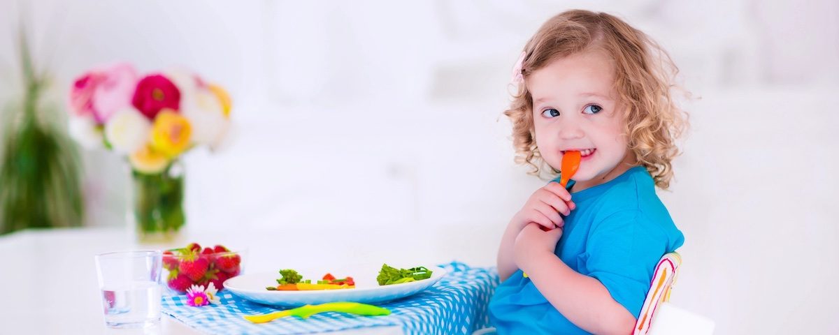 Bambino beve acqua durante una colazione con frutta e cereali integrali