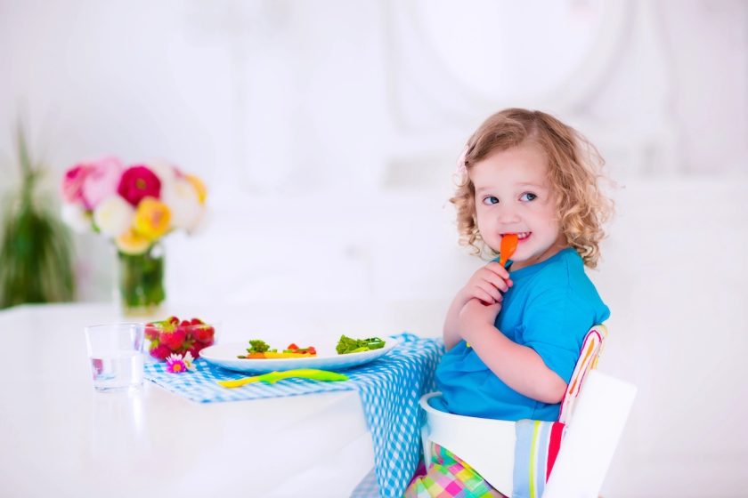 Bambino beve acqua durante una colazione con frutta e cereali integrali