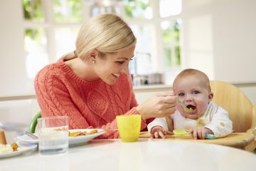 Genitore imbocca un bambino durante lo svezzamento